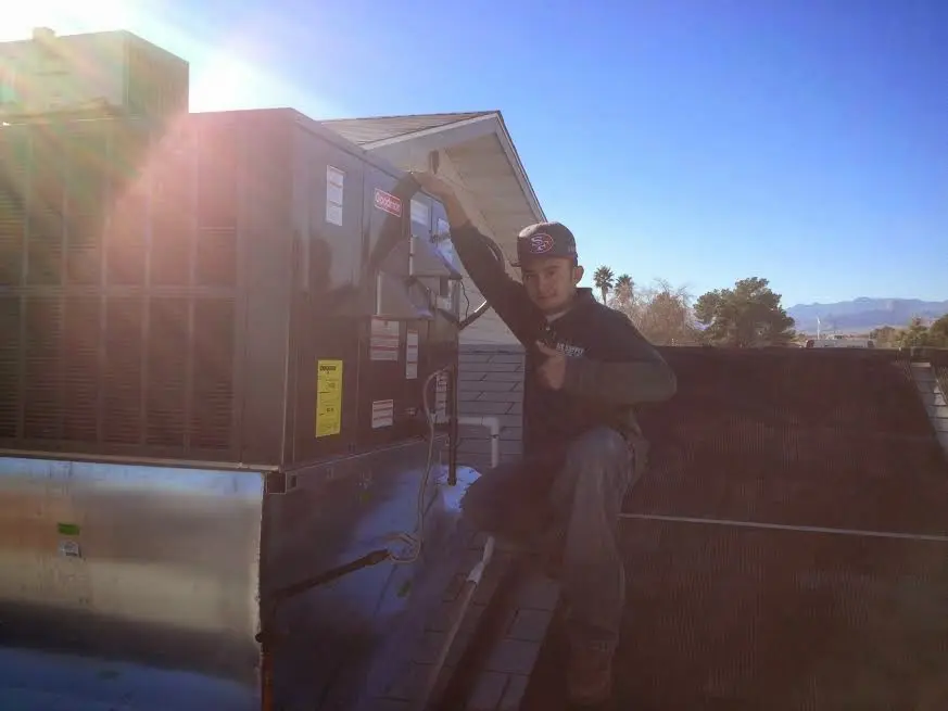 HVAC technician performing Boiler Repair on a rooftop unit in Salisbury